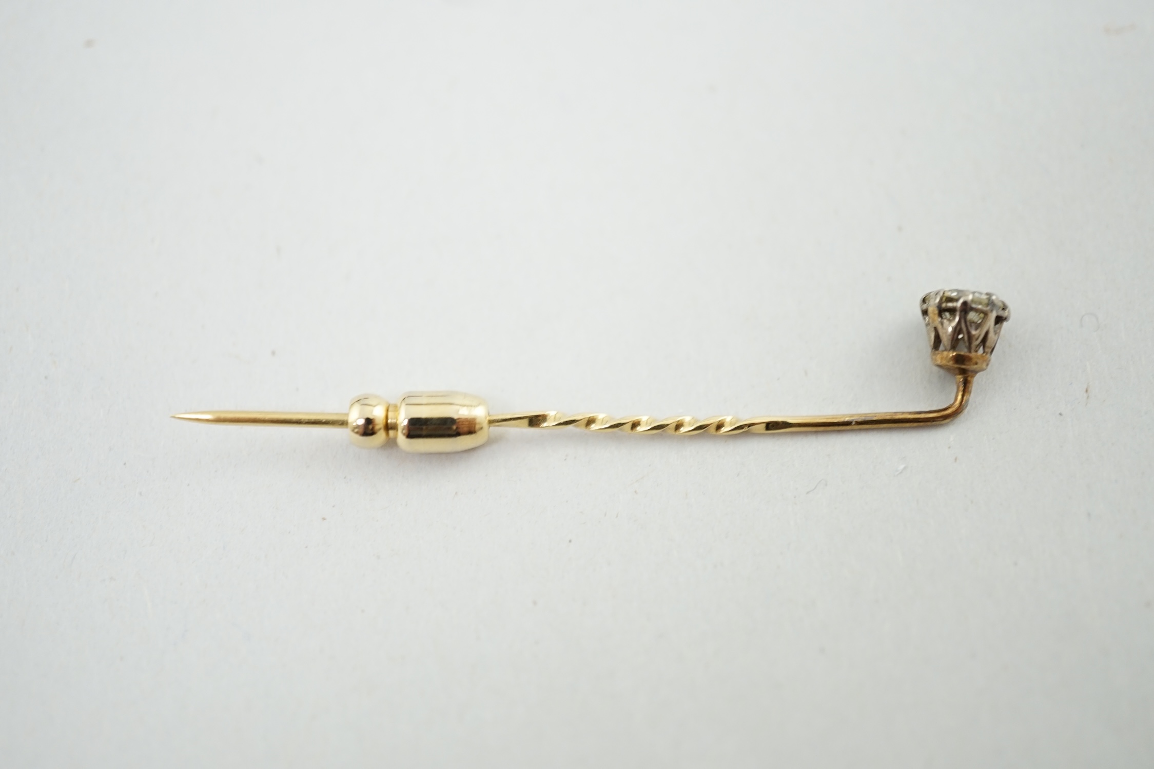 A late Victorian gold and solitaire diamond set stick pin